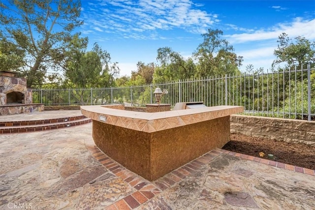 view of patio featuring an outdoor stone fireplace