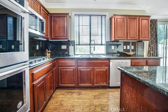 kitchen featuring tasteful backsplash, dark stone counters, sink, and stainless steel appliances