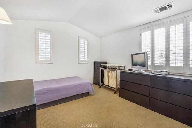 bedroom with light colored carpet, vaulted ceiling, and multiple windows