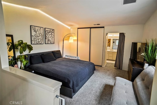 carpeted bedroom featuring connected bathroom and a closet