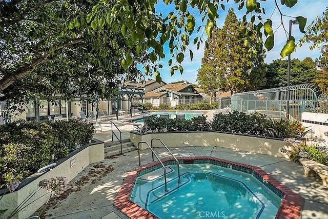 view of swimming pool with a community hot tub and a patio