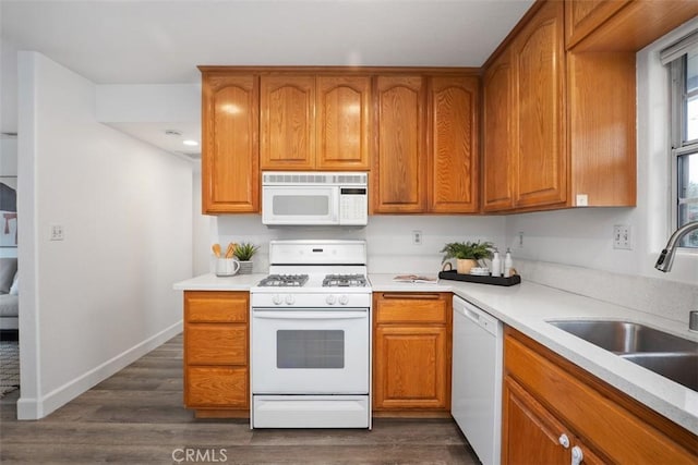 kitchen with dark hardwood / wood-style flooring, sink, and white appliances