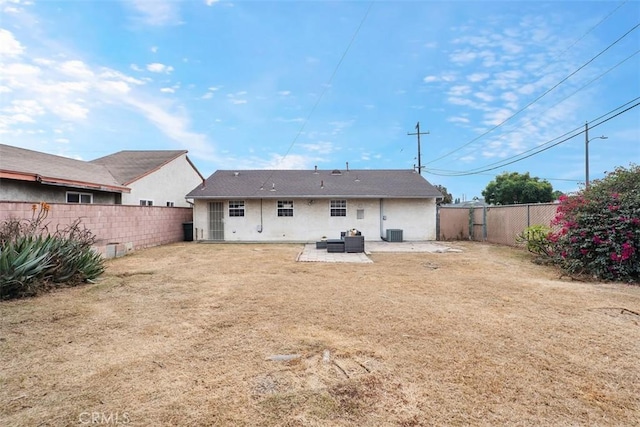 back of property with cooling unit, a yard, and a patio