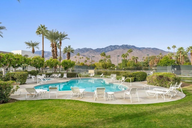 view of swimming pool with a lawn, a patio area, and a mountain view