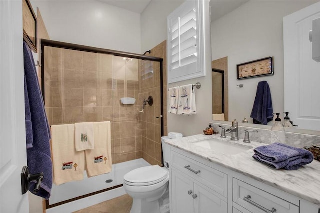 bathroom featuring toilet, a shower with door, and vanity