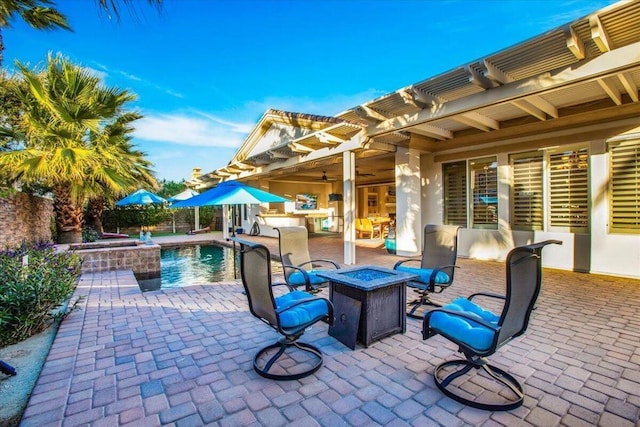 view of patio with a pool with hot tub and a fire pit