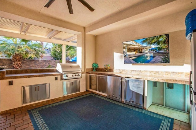 view of patio with ceiling fan, a grill, and exterior kitchen