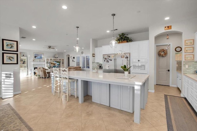 kitchen with light tile patterned floors, pendant lighting, a large island, and high quality fridge