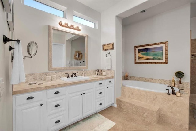 bathroom with tiled bath, vanity, and tile patterned flooring