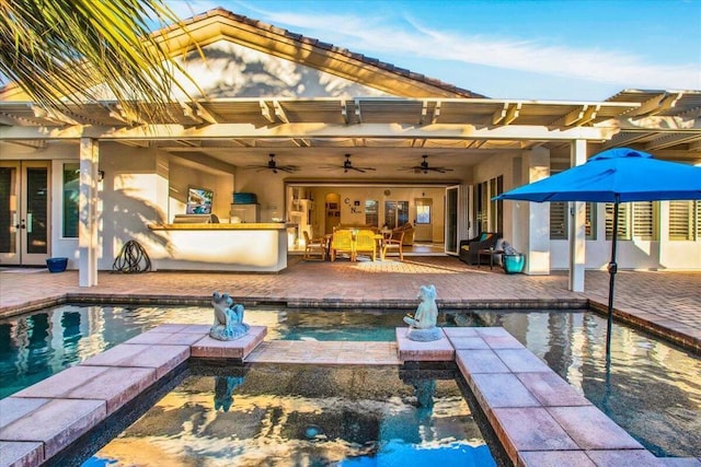 view of pool featuring ceiling fan, a patio area, an in ground hot tub, and a bar