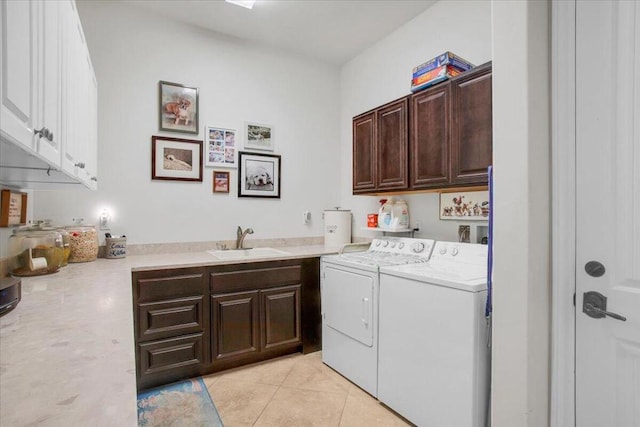 laundry room featuring light tile patterned floors, sink, washing machine and clothes dryer, and cabinets