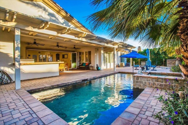 view of swimming pool with ceiling fan, exterior bar, a patio, and an in ground hot tub