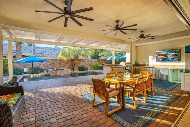 view of patio / terrace featuring grilling area, pool water feature, and an outdoor kitchen