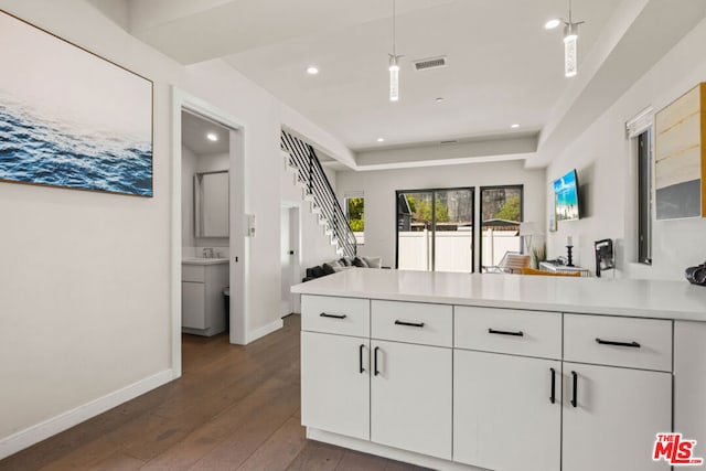 kitchen featuring white cabinetry, pendant lighting, dark hardwood / wood-style flooring, and kitchen peninsula