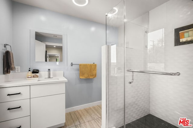 bathroom with vanity and a shower with door