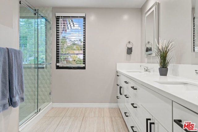 bathroom with walk in shower, vanity, and tile patterned flooring