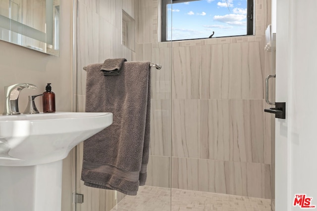 bathroom featuring an enclosed shower and sink