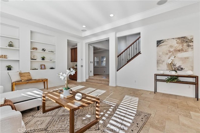 living room with built in features and ornamental molding