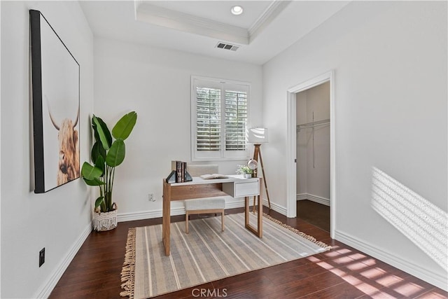 office space featuring dark hardwood / wood-style flooring, ornamental molding, and a raised ceiling