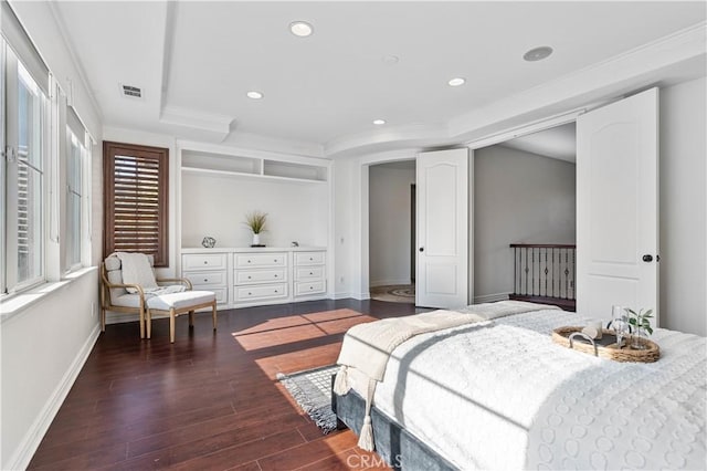 bedroom featuring dark hardwood / wood-style flooring, a tray ceiling, and ornamental molding