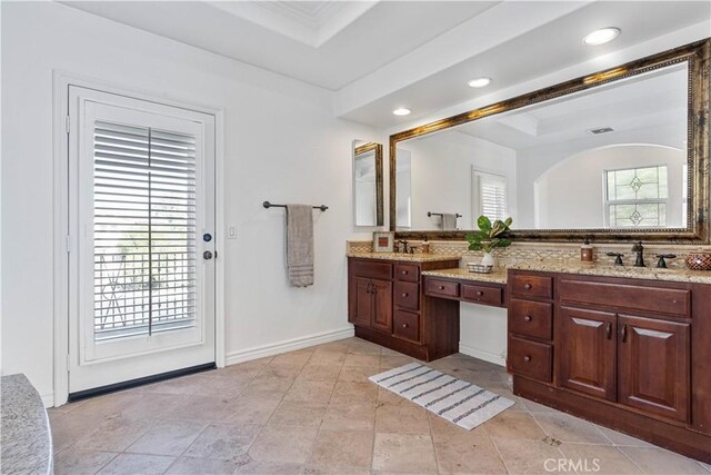 bathroom with vanity, decorative backsplash, and a tray ceiling