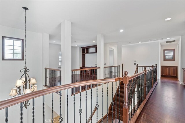 hallway with an inviting chandelier and dark hardwood / wood-style flooring