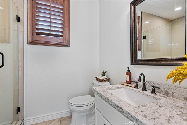 bathroom with tile patterned floors, toilet, vanity, and an enclosed shower