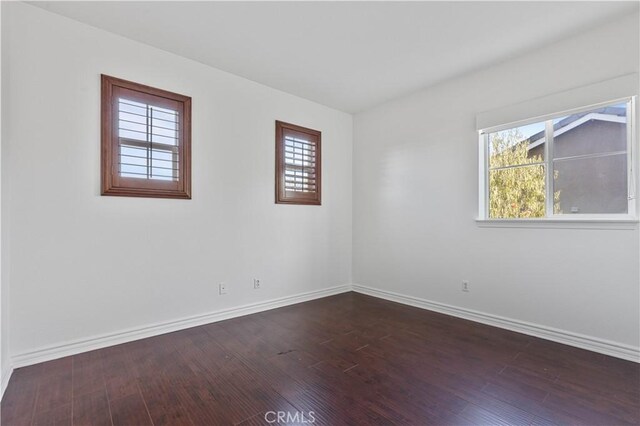 spare room with dark hardwood / wood-style flooring