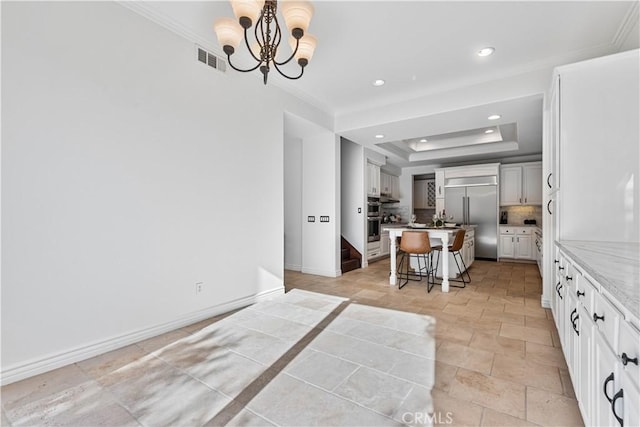 kitchen featuring a notable chandelier, a center island, hanging light fixtures, appliances with stainless steel finishes, and a kitchen breakfast bar