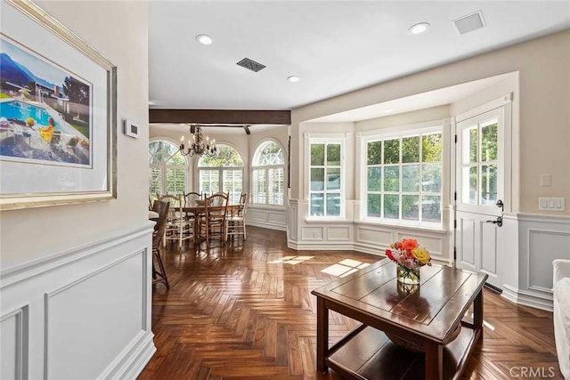 sunroom featuring a wealth of natural light and a notable chandelier