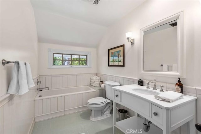 bathroom featuring toilet, vanity, lofted ceiling, tile patterned floors, and a bathtub