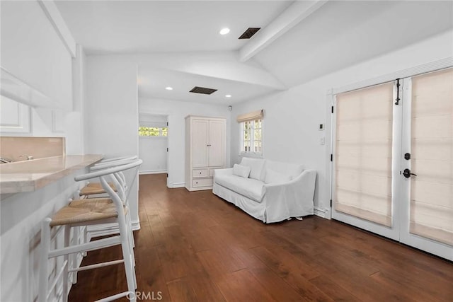 interior space with dark hardwood / wood-style flooring and lofted ceiling with beams