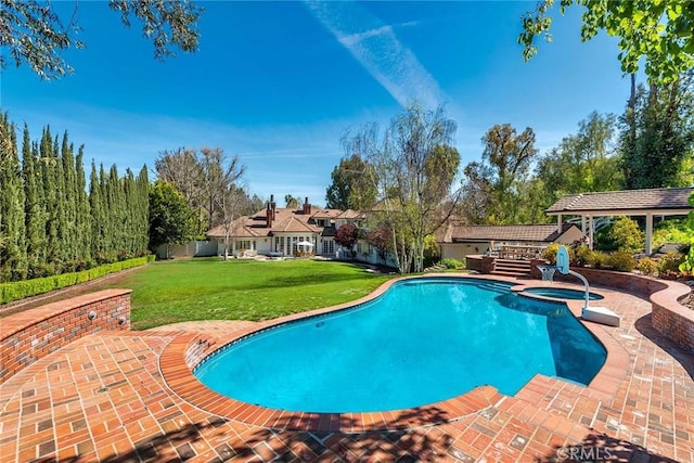 view of pool with an in ground hot tub, a yard, and a patio