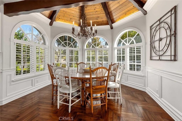 dining space with beamed ceiling, an inviting chandelier, dark parquet floors, ornamental molding, and wooden ceiling