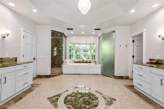 bathroom featuring a shower with shower door and vanity