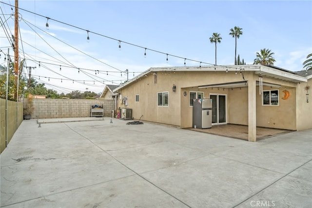 rear view of property featuring central AC and a patio area