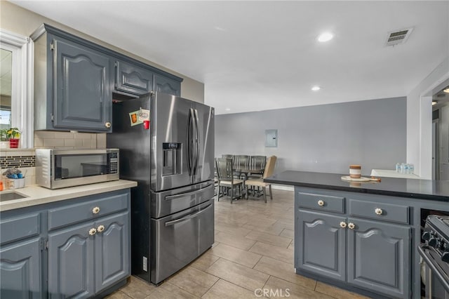 kitchen with appliances with stainless steel finishes, decorative backsplash, and sink