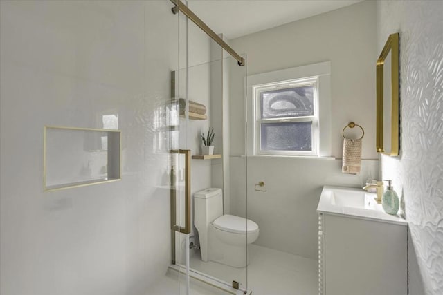 bathroom featuring a shower with door, toilet, and vanity