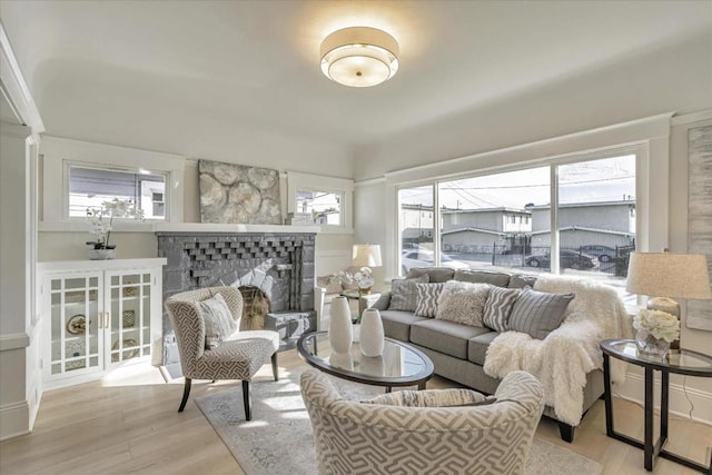 living room with a healthy amount of sunlight, a fireplace, and light hardwood / wood-style floors