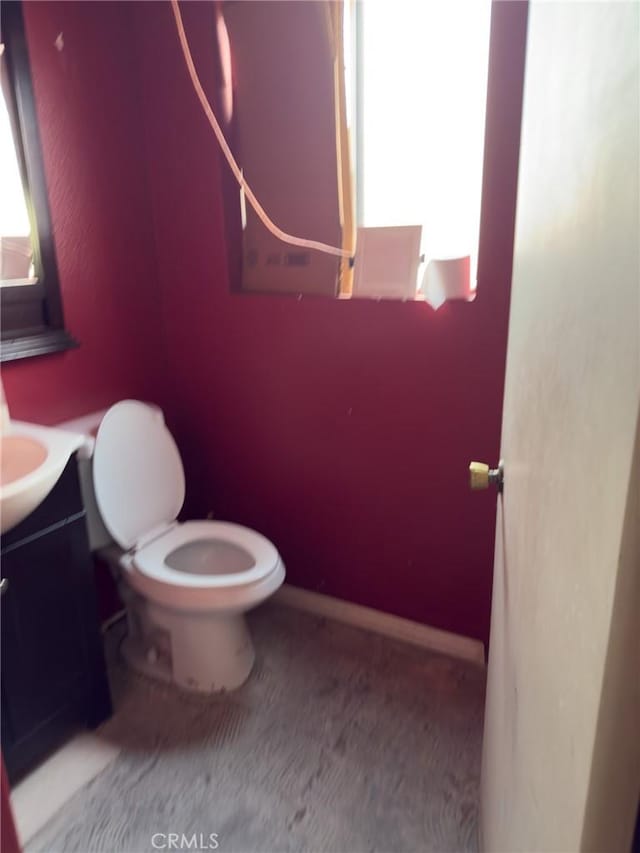 bathroom with a wealth of natural light, toilet, and vanity