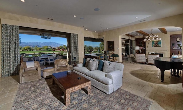 living room featuring a mountain view, beam ceiling, and a chandelier