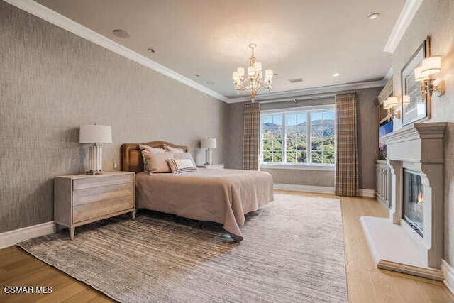 bedroom featuring an inviting chandelier, crown molding, and light hardwood / wood-style flooring