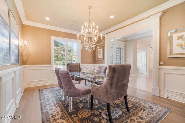 dining room featuring light wood-type flooring, an inviting chandelier, and ornamental molding