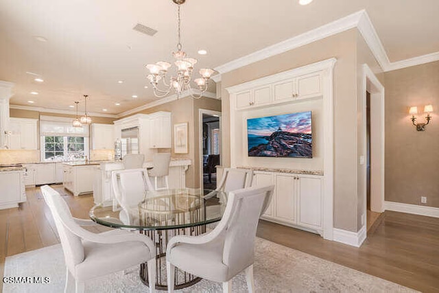 dining room featuring a notable chandelier, crown molding, and light hardwood / wood-style floors