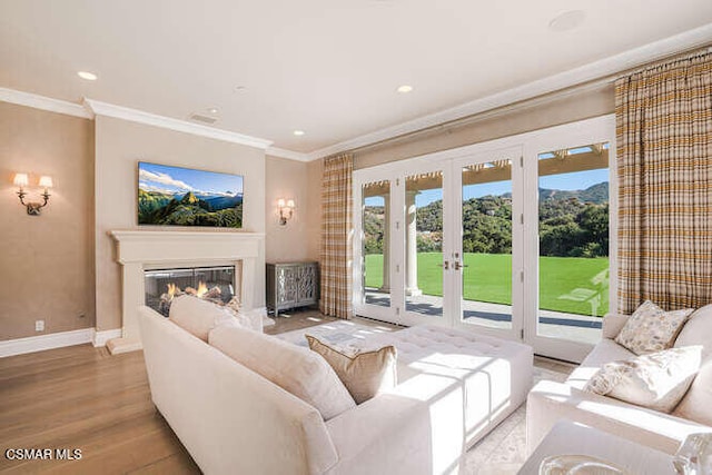 living room with light wood-type flooring, crown molding, and french doors