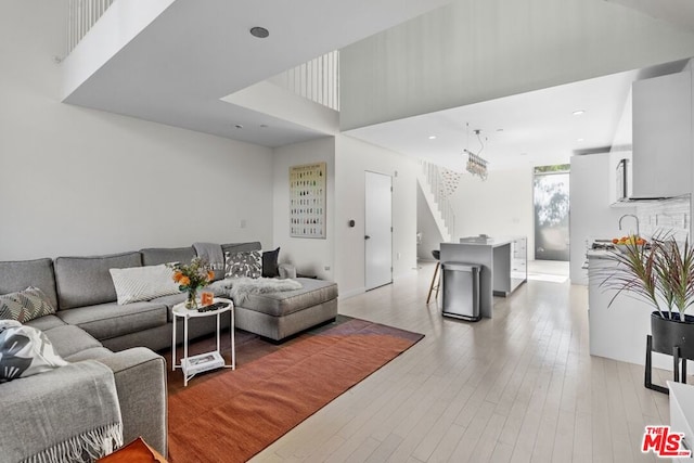 living room featuring a towering ceiling and light wood-type flooring