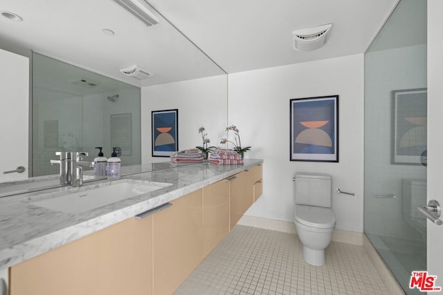 bathroom featuring tile patterned floors, toilet, vanity, and walk in shower