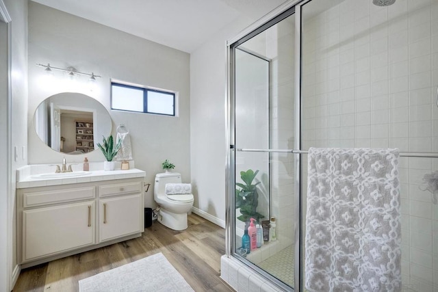 bathroom with hardwood / wood-style flooring, toilet, an enclosed shower, and vanity