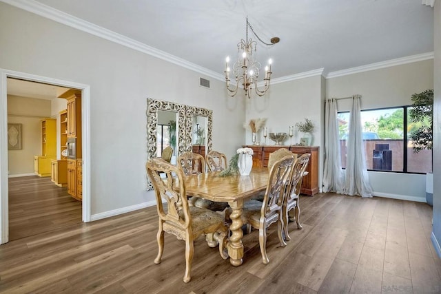 dining space featuring crown molding, dark wood-type flooring, and an inviting chandelier