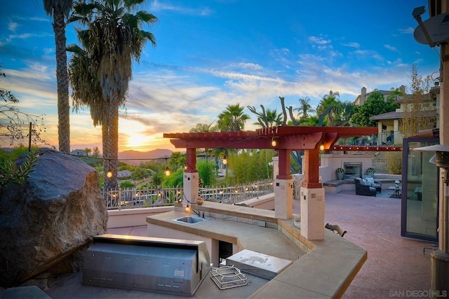 patio terrace at dusk featuring area for grilling and sink